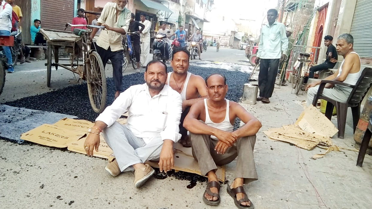 When the potholes were not filled properly, the municipality chairman's husband sat on the road.