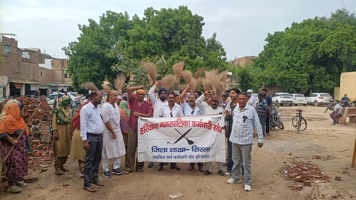 Sanitation workers demonstrated by turning broom upside down regarding their demands