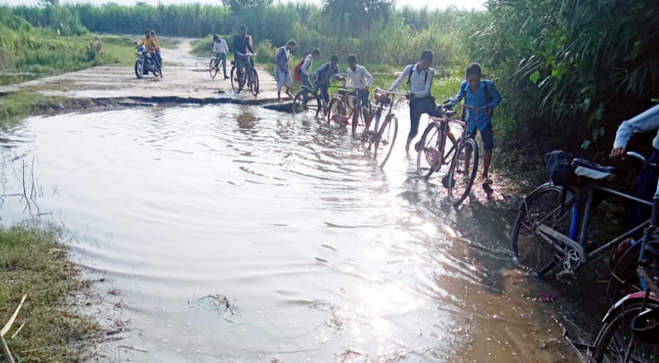 School children risk their lives to cross the slippery bridge.