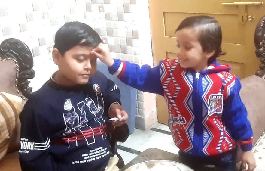 Sisters wish long life of brothers by applying tilak to them