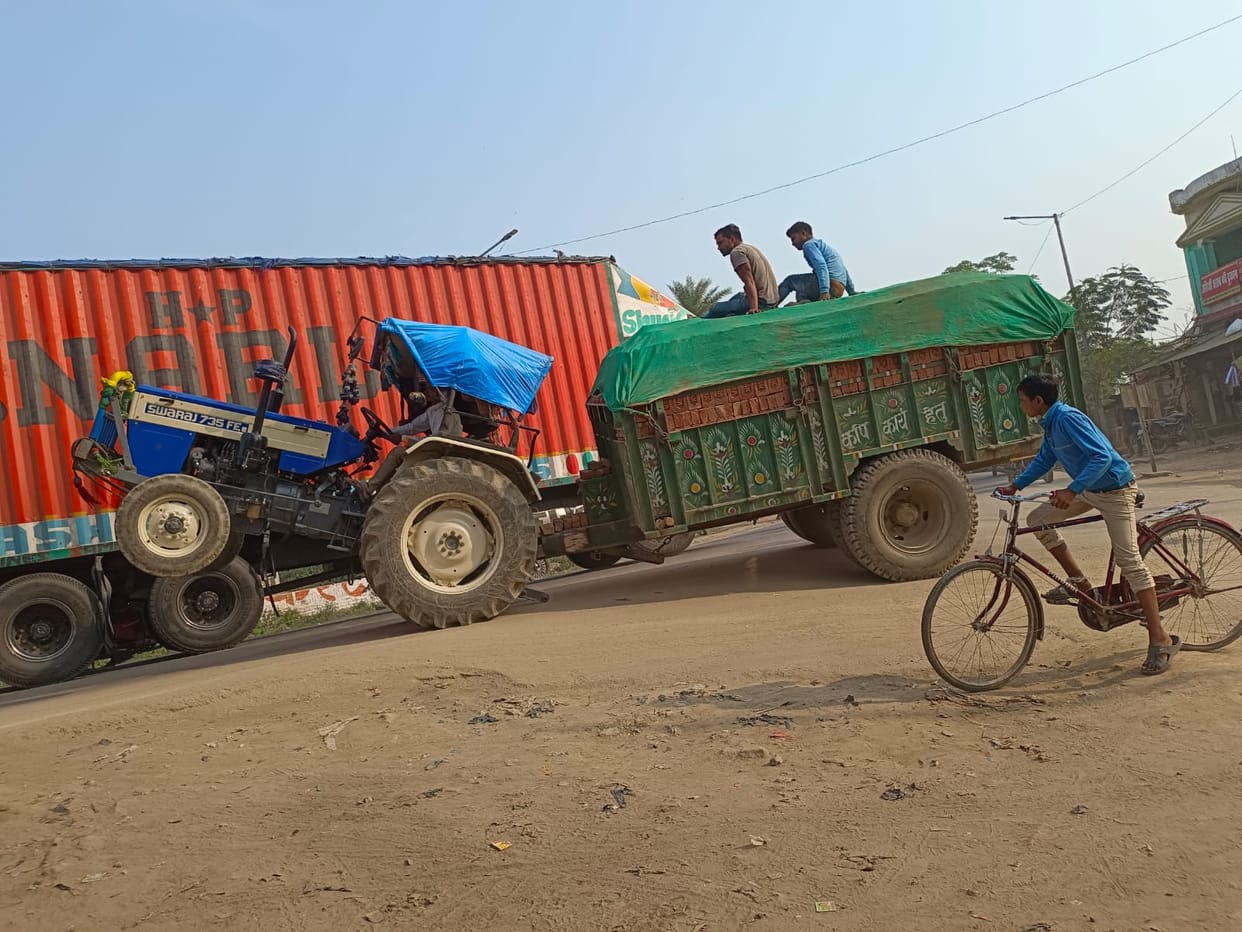 Dangerous stunt of overloaded tractor-trolleys on the road