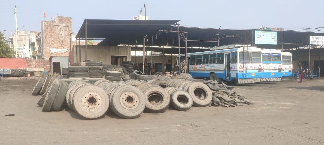 Tires lying in the workshop of Fatehabad bus stand and buses coming for repair.