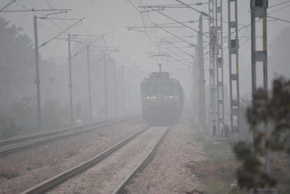 शहर में फैले कोहरे में आती ट्रेन।