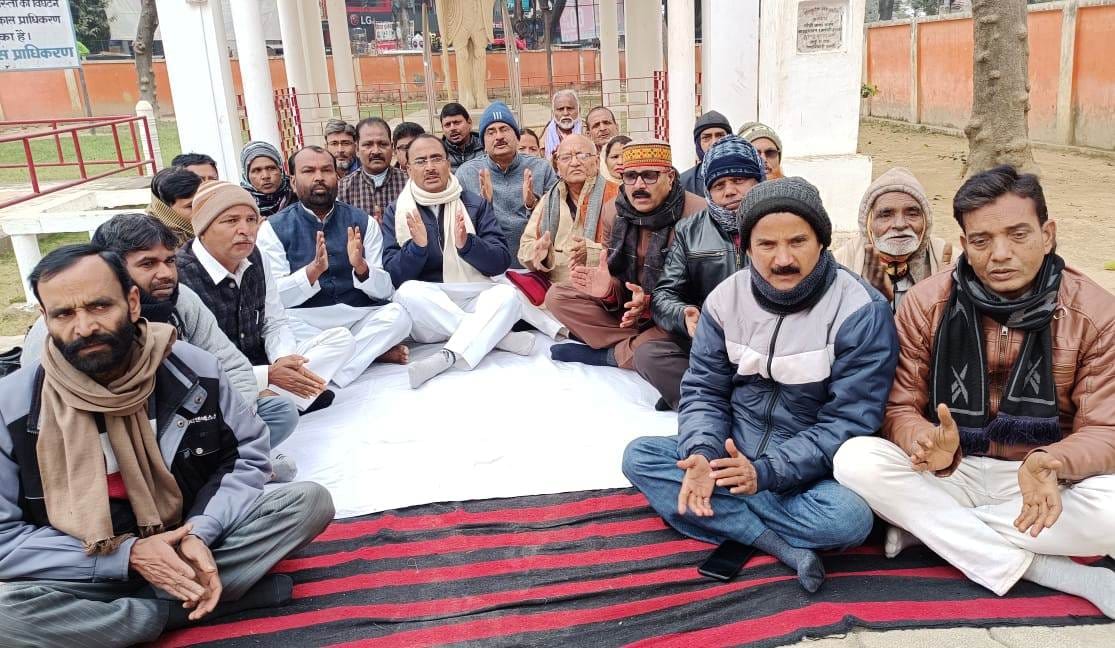 Congressmen sitting in front of Gandhi statue in protest