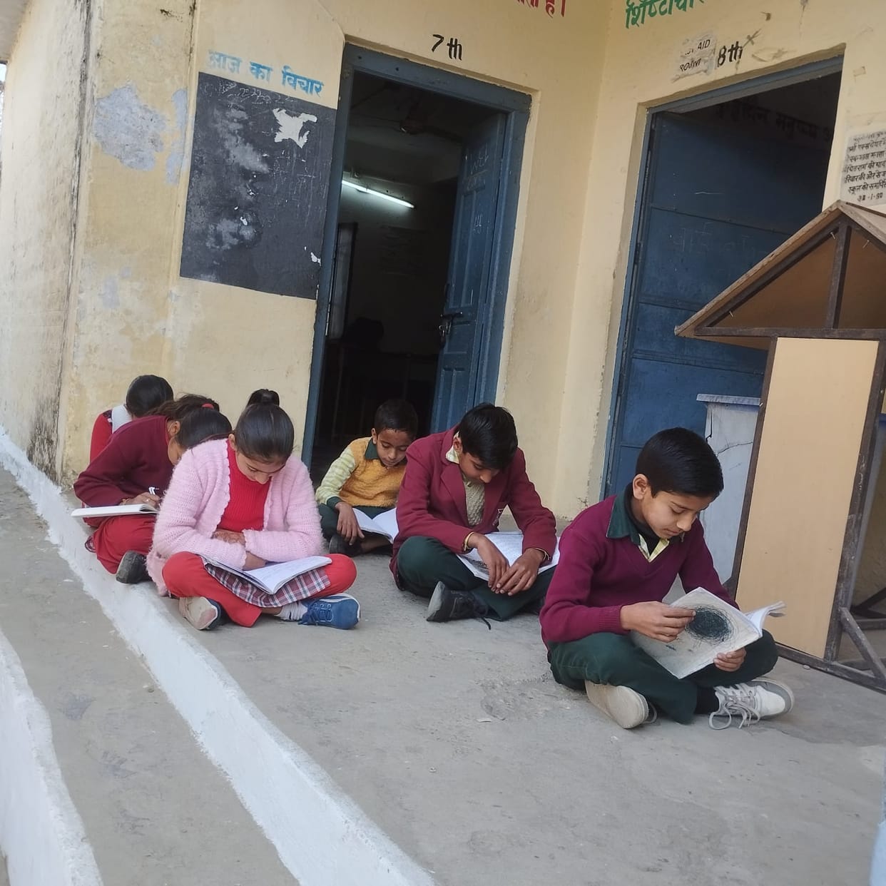 In the harsh cold, students are forced to study on sackcloth in the verandah.