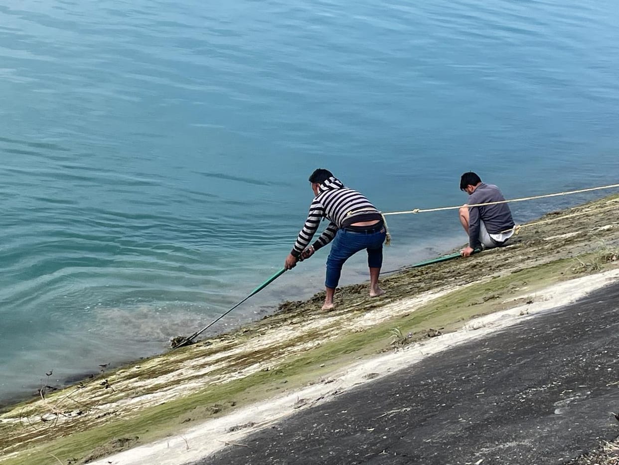 Workers engaged in repairing the crack found in the power channel