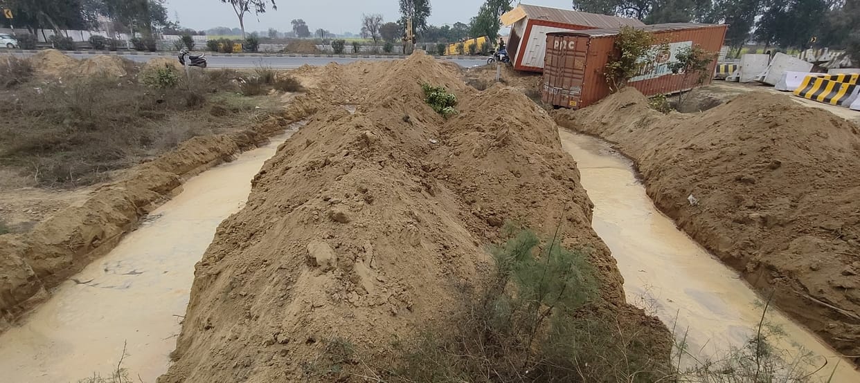 Two deep pits dug along the National Highway, filled with water