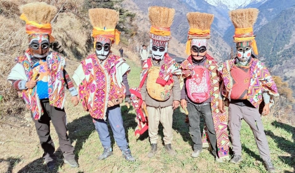 People dancing wearing masks in Tirthan Valley