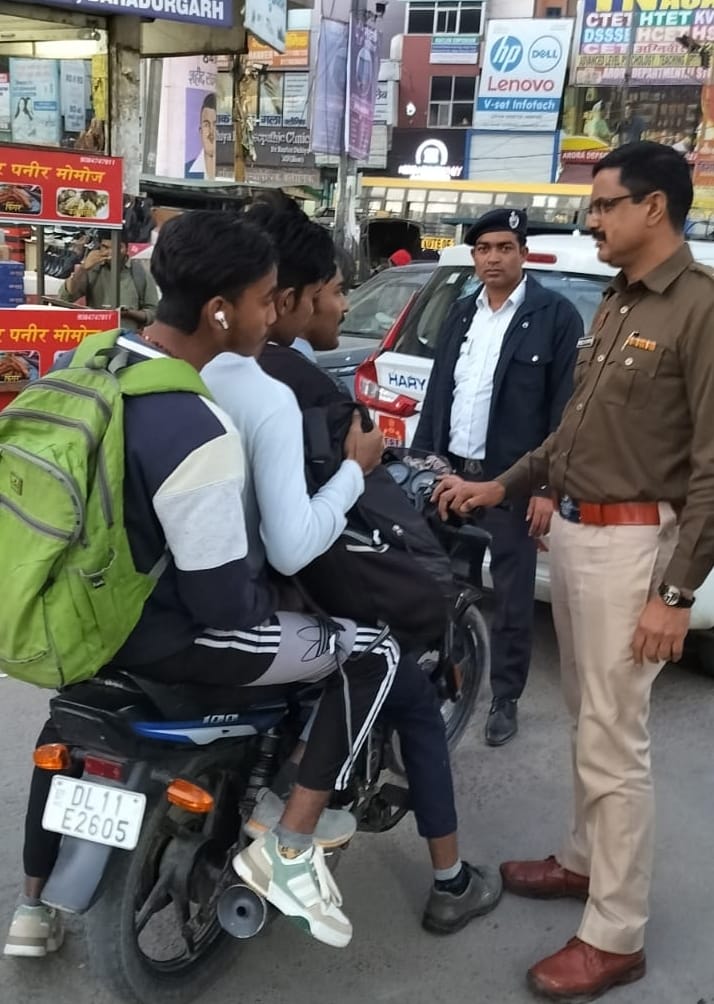 Traffic police issuing challan to stop triple riding on two wheelers
