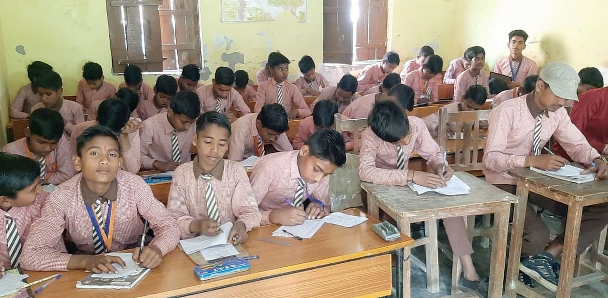 Sitting side by side, children wrote answers to the questions.