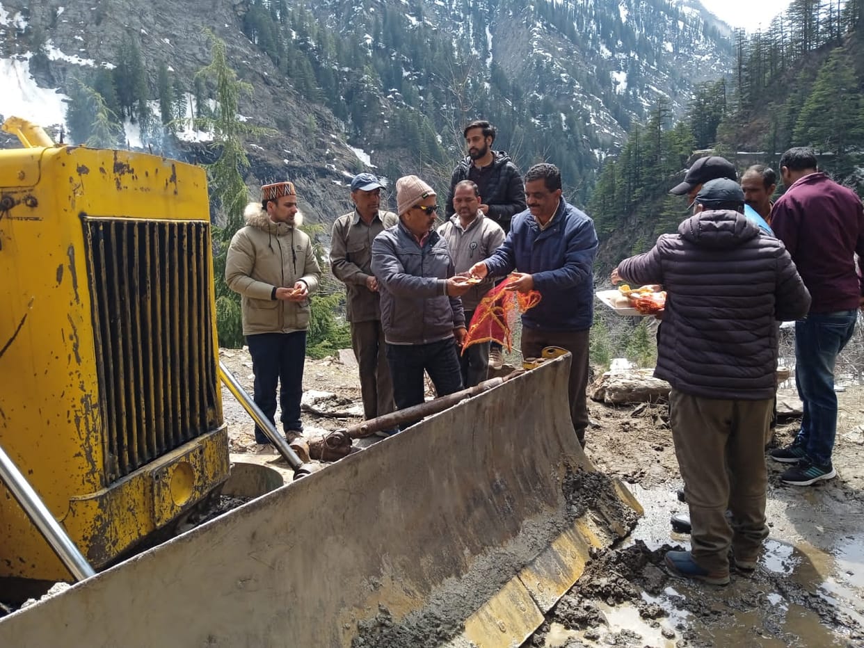 After performing puja, machinery is engaged in the restoration of Sach Pass.