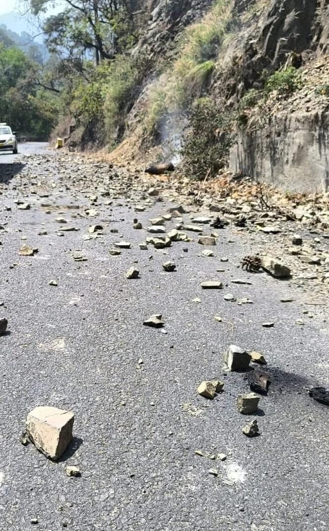 Stones are falling from the hill on the highway due to forest fire
