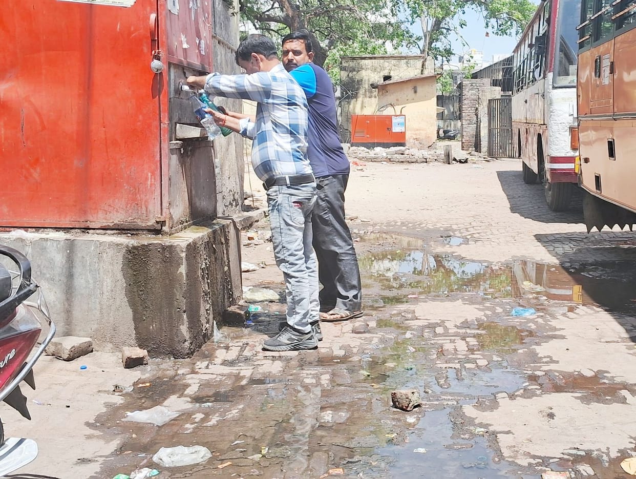 Passengers are distressed in the scorching heat, water coolers are lying unused surrounded by filth.