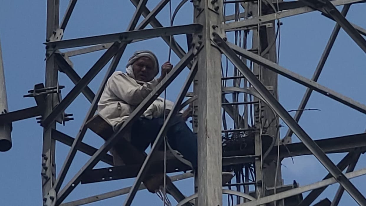 Troubled by neighbors' quarrel, an elderly man climbed a mobile tower and was brought down by the police after five hours.