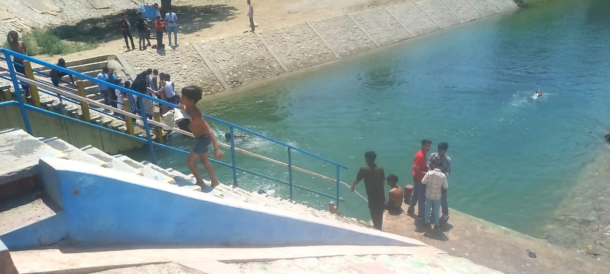 Young men and children are risking their lives by diving into the canal.