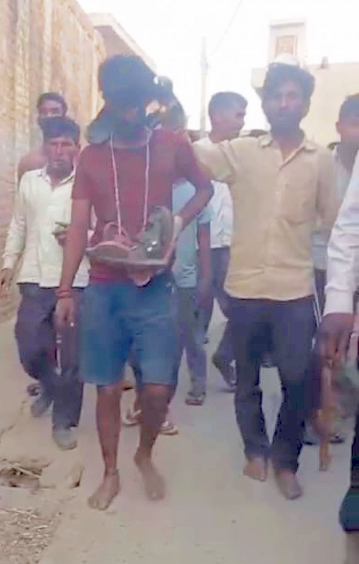 While carrying the woman, the young man was beaten, garlanded with shoes, blackened and paraded around.
