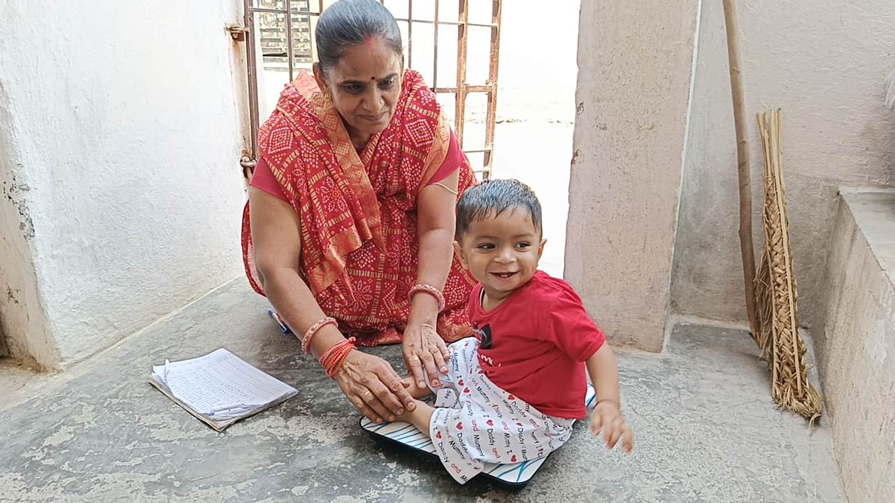 बच्चो का वजन नापती आंगनवाड़ी कार्यकर्ता
