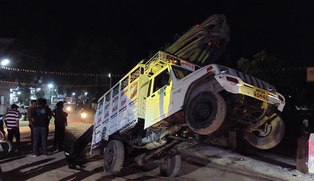 On the middle of the road, a pickup vehicle loaded with overloaded bars swung in the air