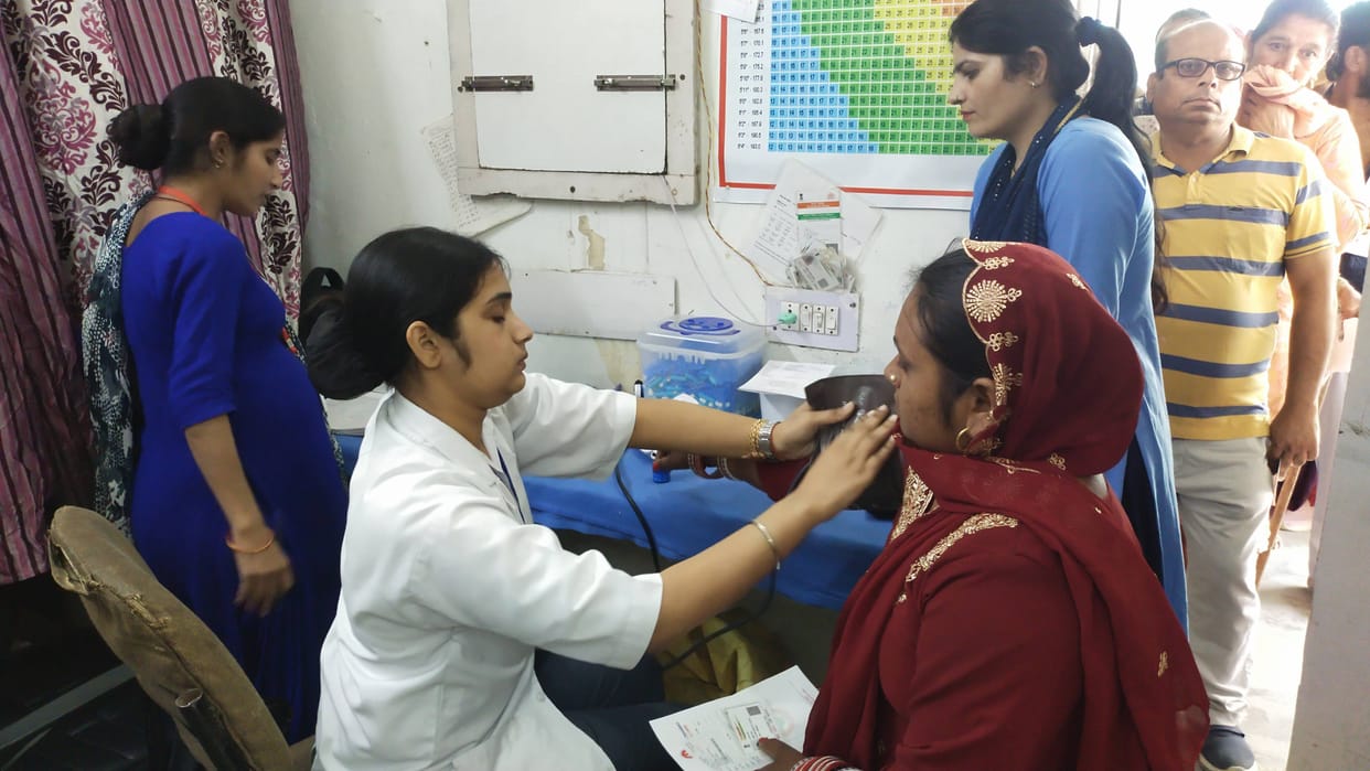 Health worker checking BP of patients in Fatehabad Civil Hospital.