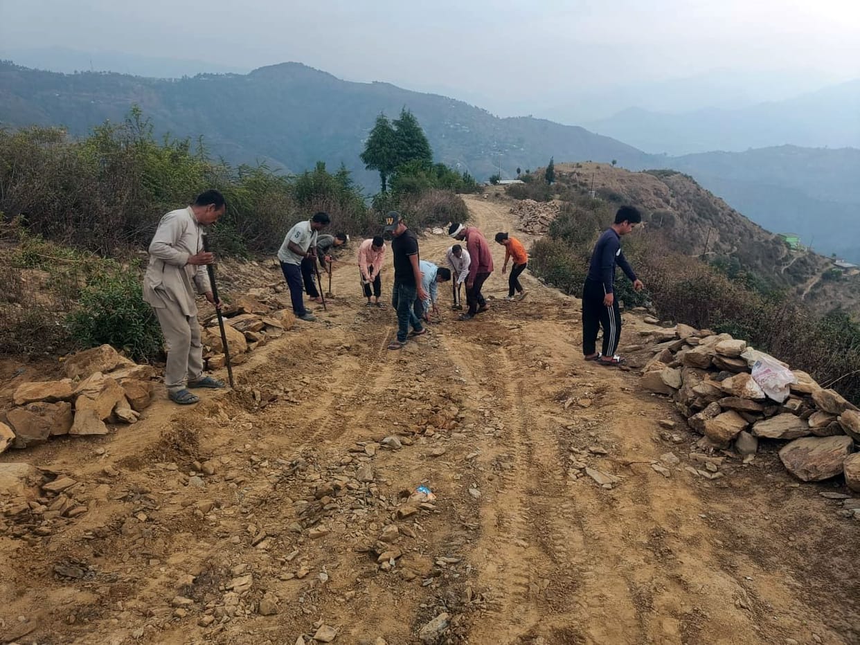 Villagers busy in repairing the road with shovel and pickaxe