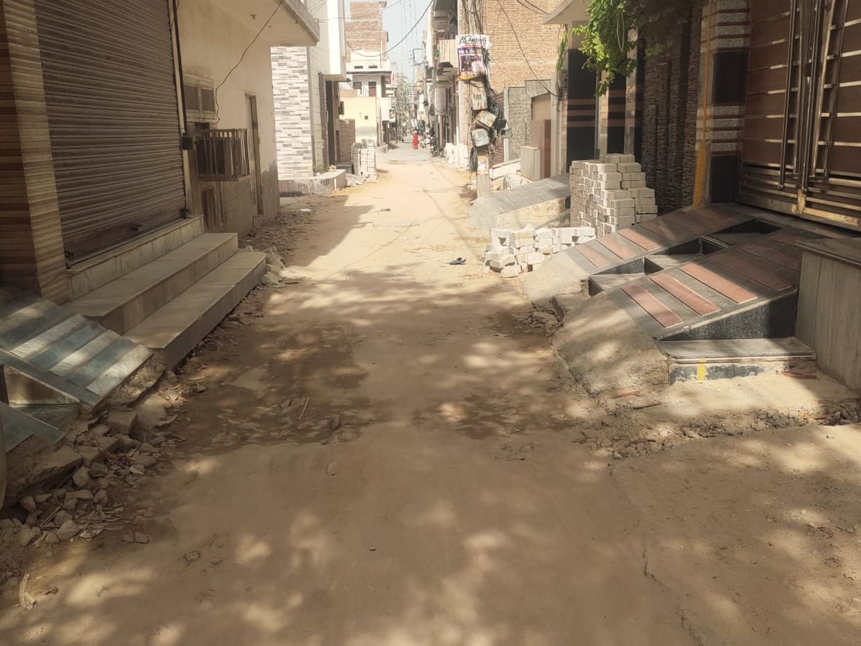 The contractor is busy in building the road without breaking the ramps built in front of the houses in the streets