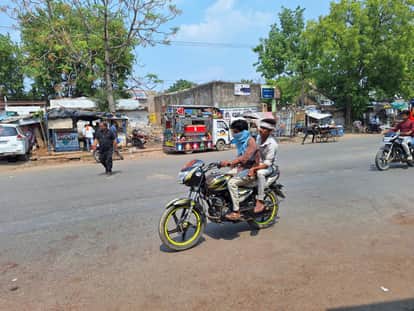 धूप से बचने मुंह बांधकर जाते बाइक सवार