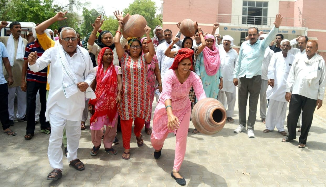 Women of Bank Colony demonstrated by breaking pots outside the Executive Engineer's office.