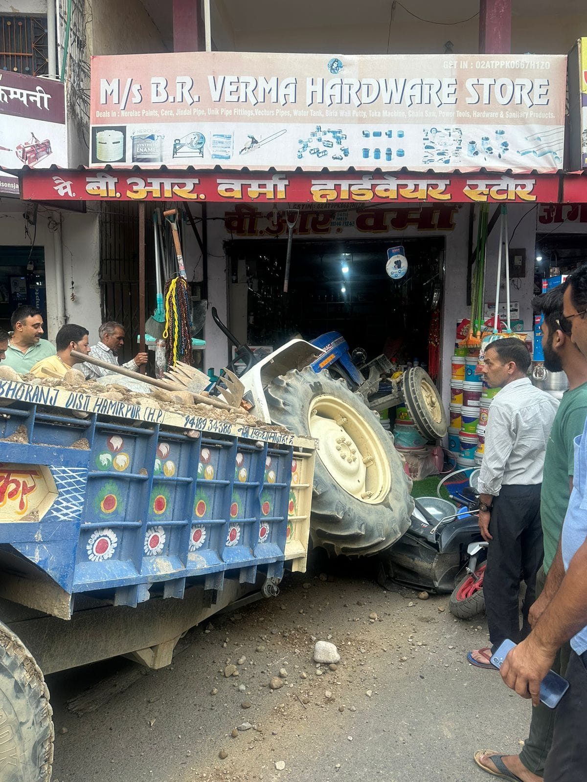 The big tire of the tractor full of stones broke loose and entered the hardware shop.