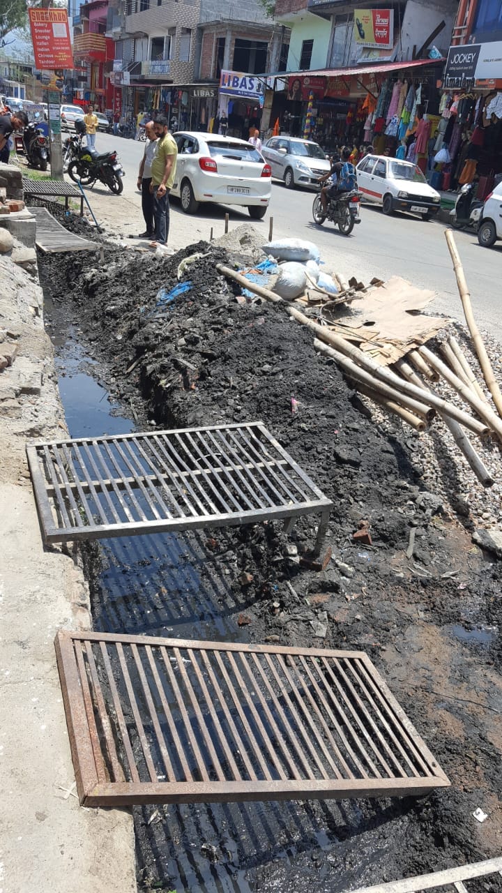 Public Works Department is busy in opening the blocked drains in Jahu market.