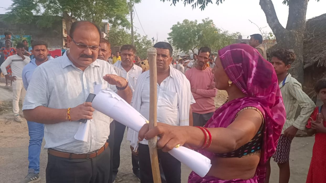 Women stood in front of JCB with sticks