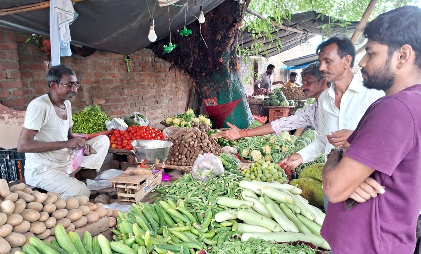 फुटकर में सब्जी खरीदते लोग। संवाद