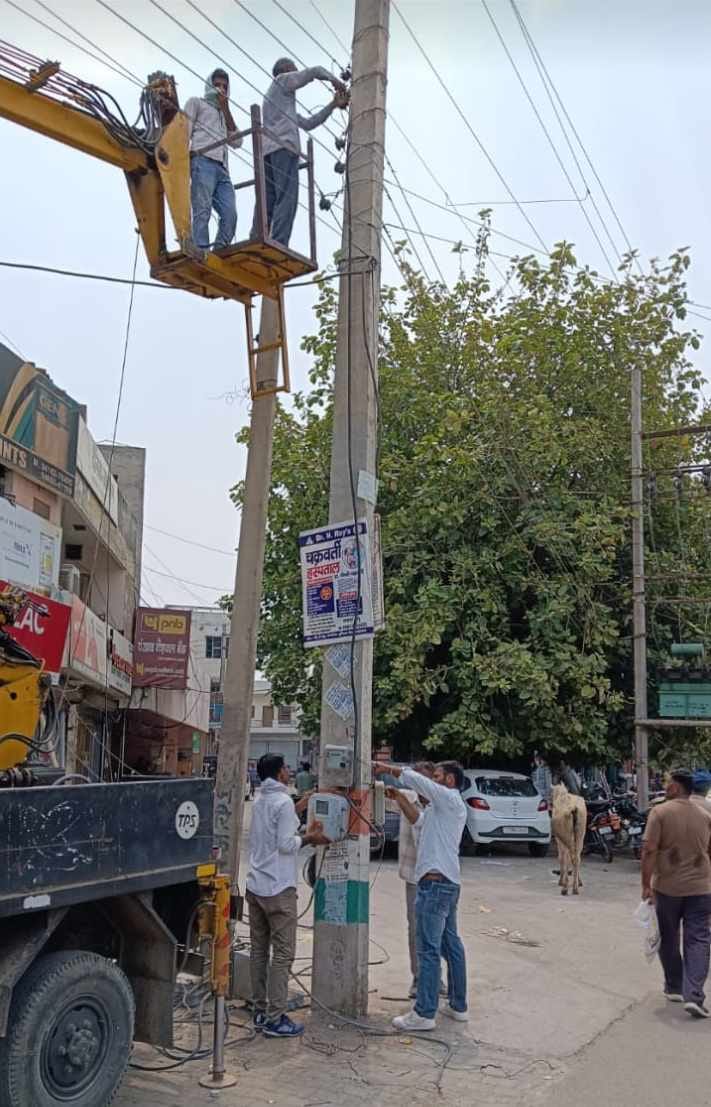 Employees engaged in electricity repair work in Fatehabad city.