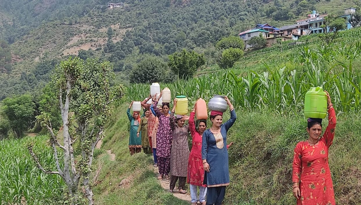 People are racing to another village for water with utensils on their heads.