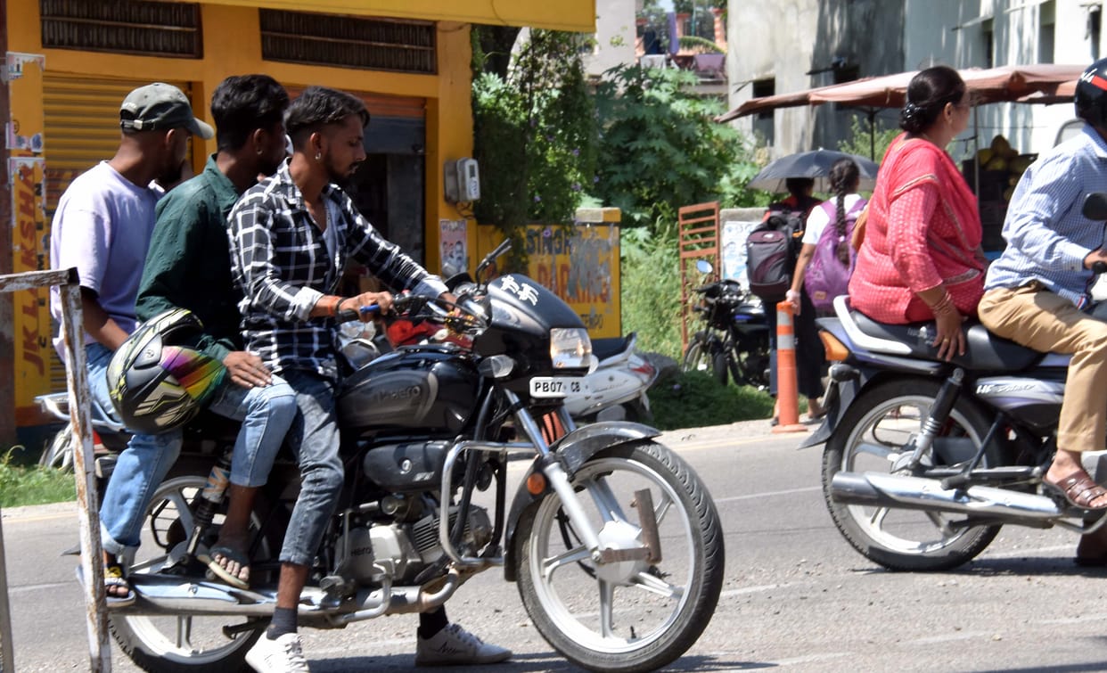 Two-wheeler drivers running on the roads without helmets and without number plates