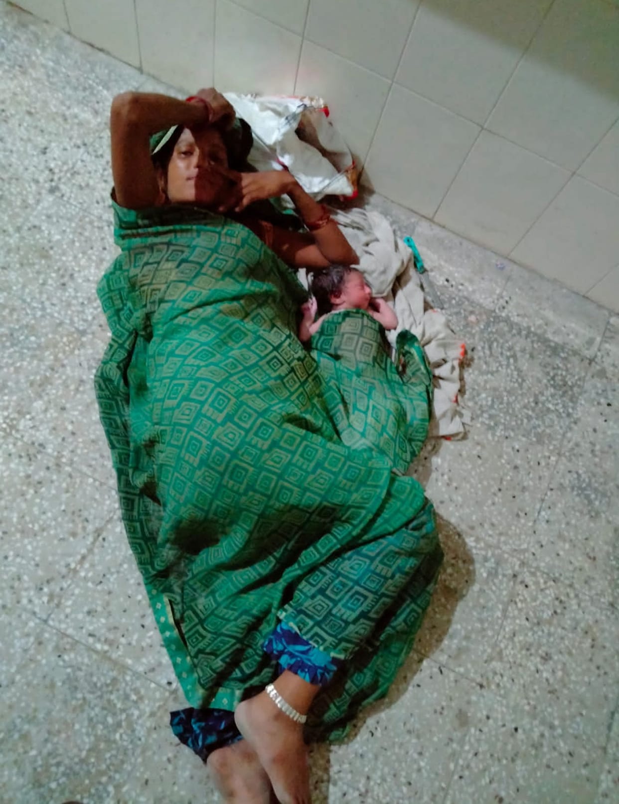 Mother lying on the floor with newborn for three hours