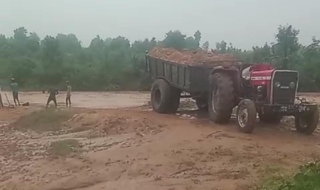 Workers are taking out sand from the swollen river and loading it into tractor, sand mafia is fearless