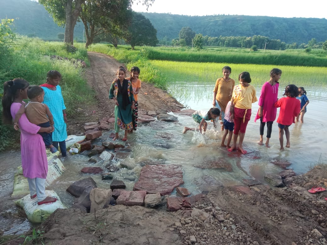 Lack of culvert in Magratola, villagers and children forced to travel through knee-deep water