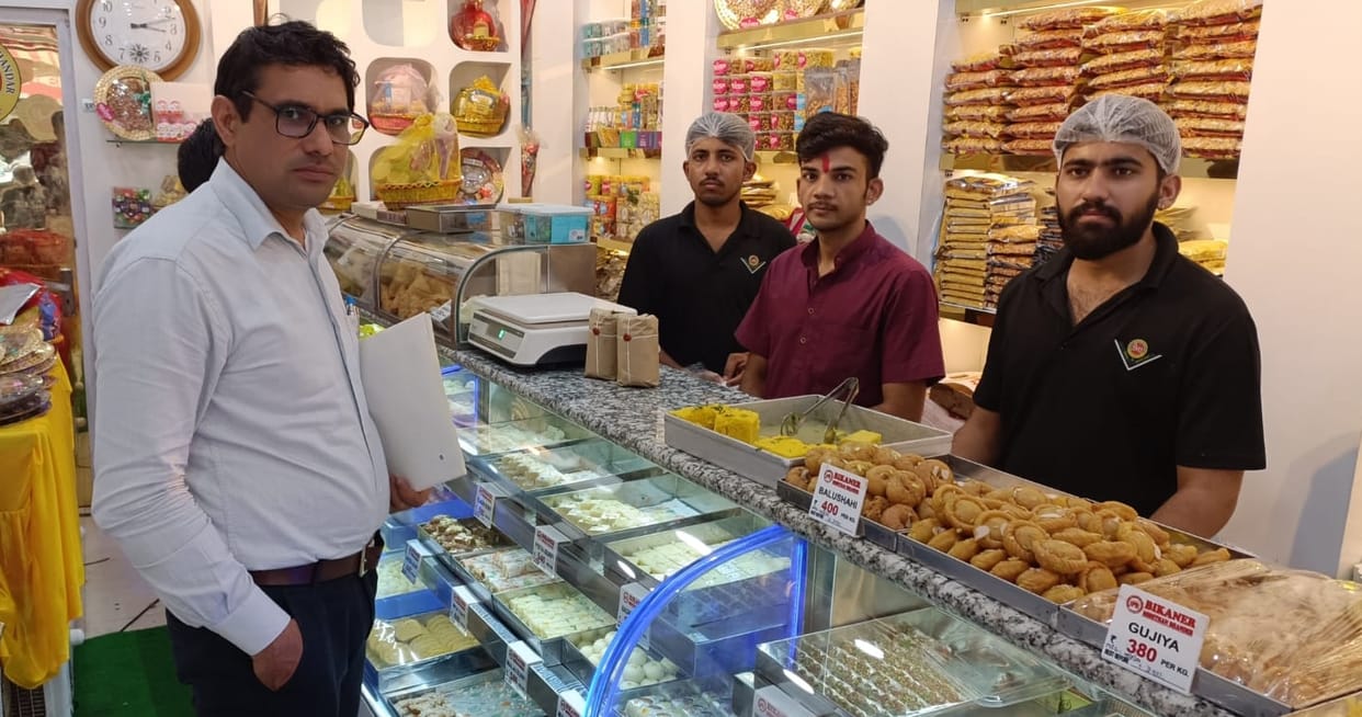 Shops full of samples of sweets, dhokla and vada pav