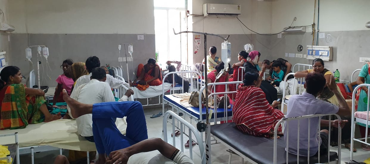 Male and female wards in district hospital are full, most patients have fever