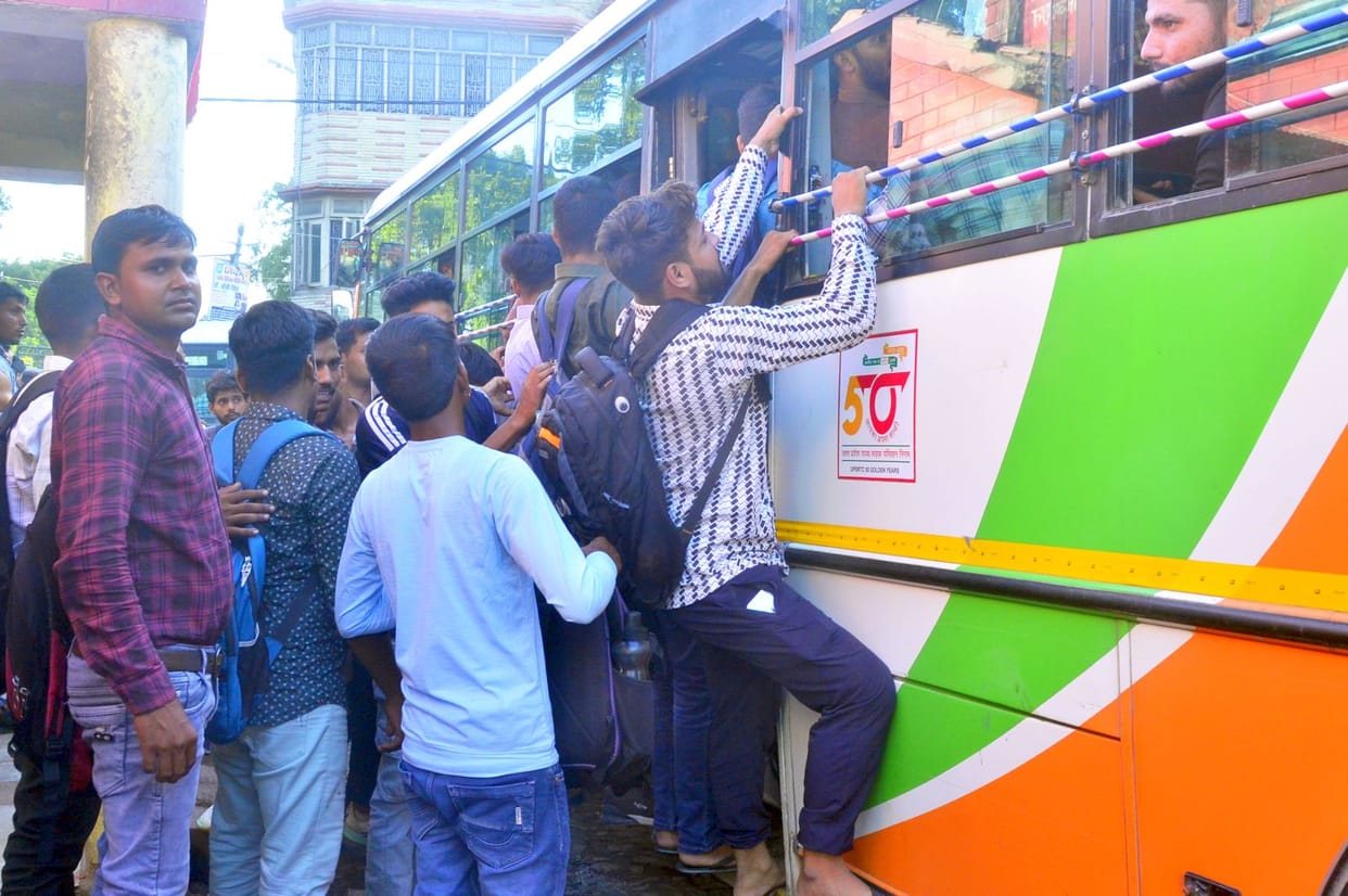 Crowd gathered in roadways buses, there was a scuffle to get a seat.
