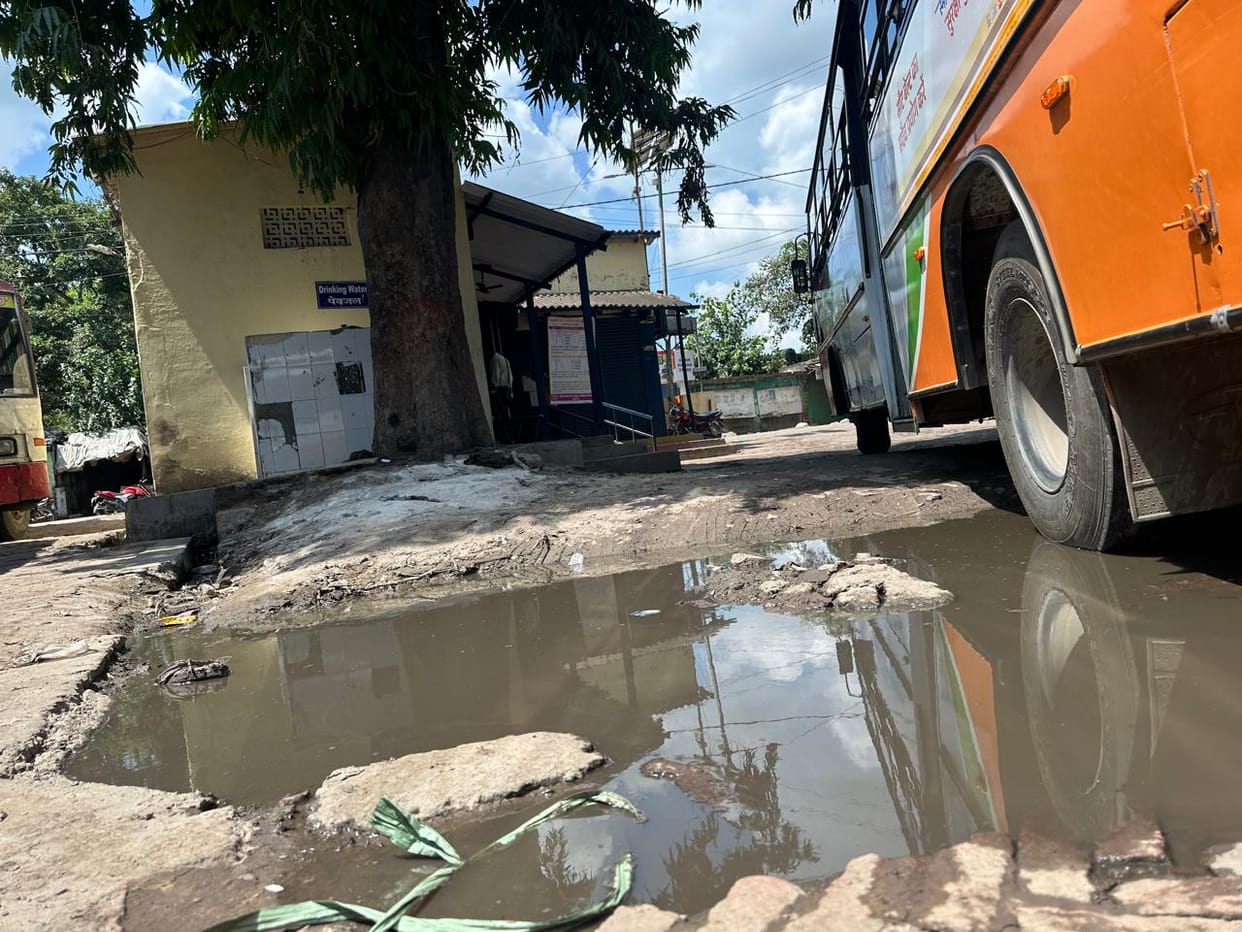 The bus station building is dilapidated, mud is everywhere