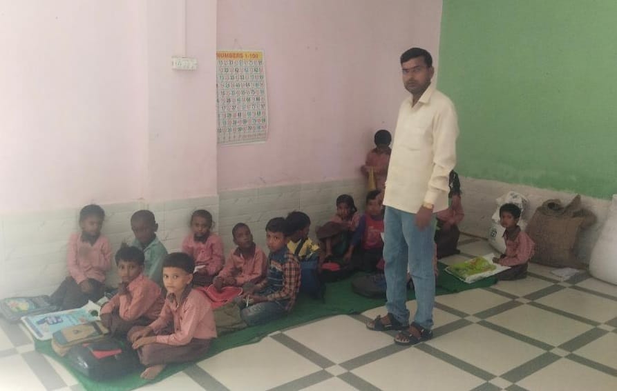Examination in council schools: Children kept writing while sitting on benches and sometimes on the floor.