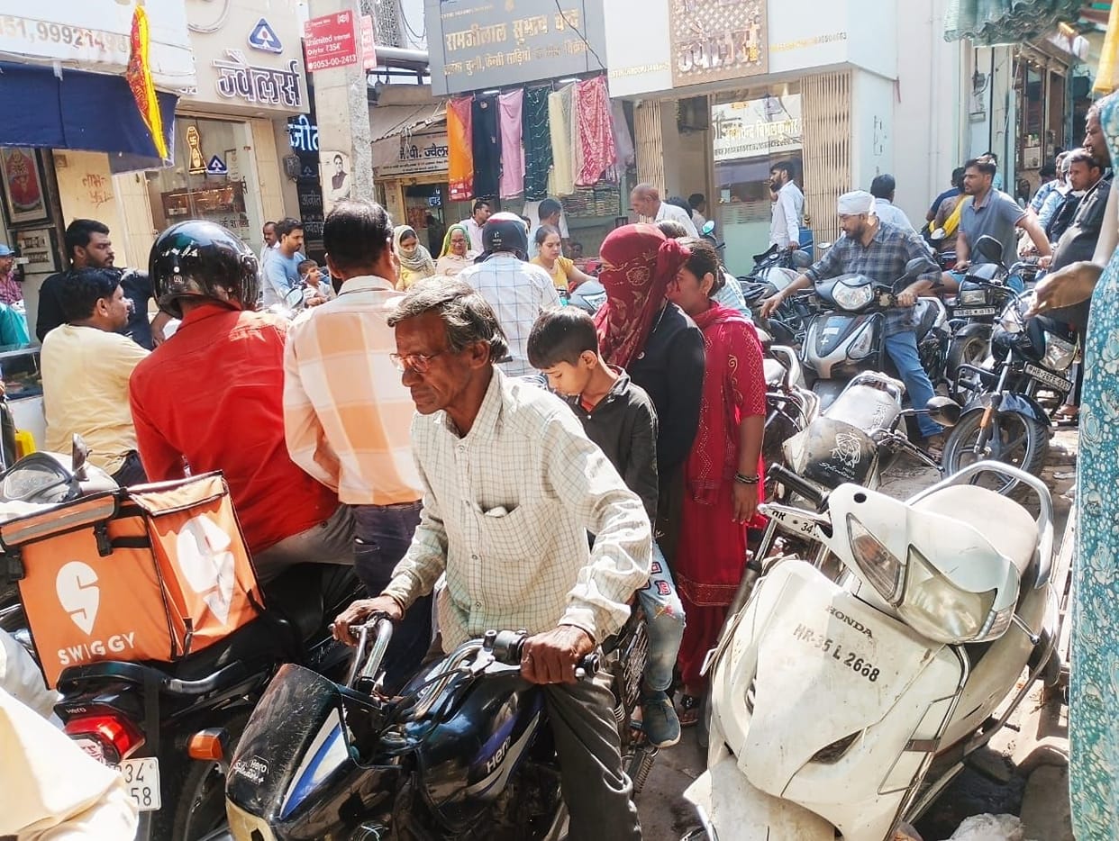 No parking in the market, pedestrians struggling in traffic jam