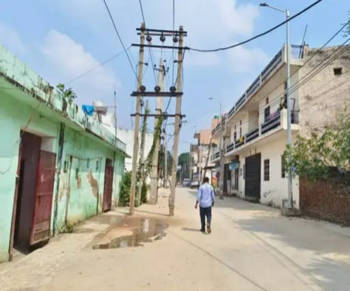 Electricity poles standing in the middle of Bhatsana Road and Santosh Colony