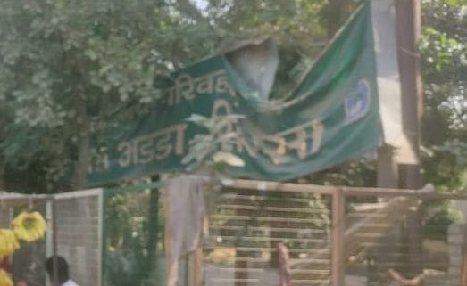 The signboard at the main entrance of the bus stand is broken