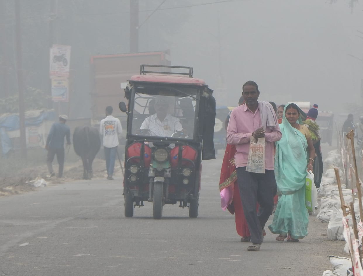People moving on the city's Khajuriya road in the fog that prevailed throughout the day.