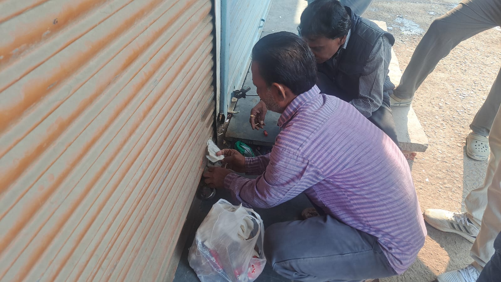 दुकान में तालाबंदी करते कर्मचारी