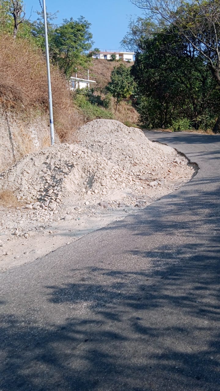 Risk of accidents increases due to pile of construction material on the roadside