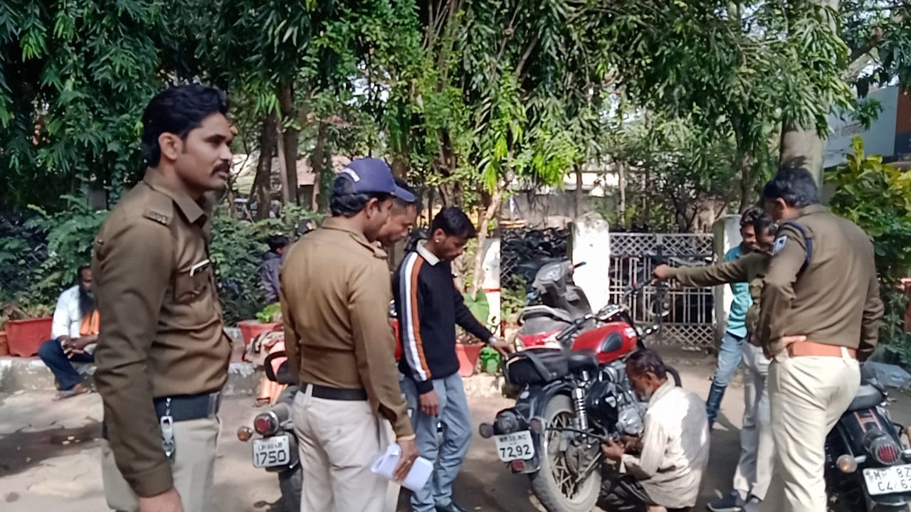 बुलेट से साइलेंसर निकालते हुए पुलिस कर्मी