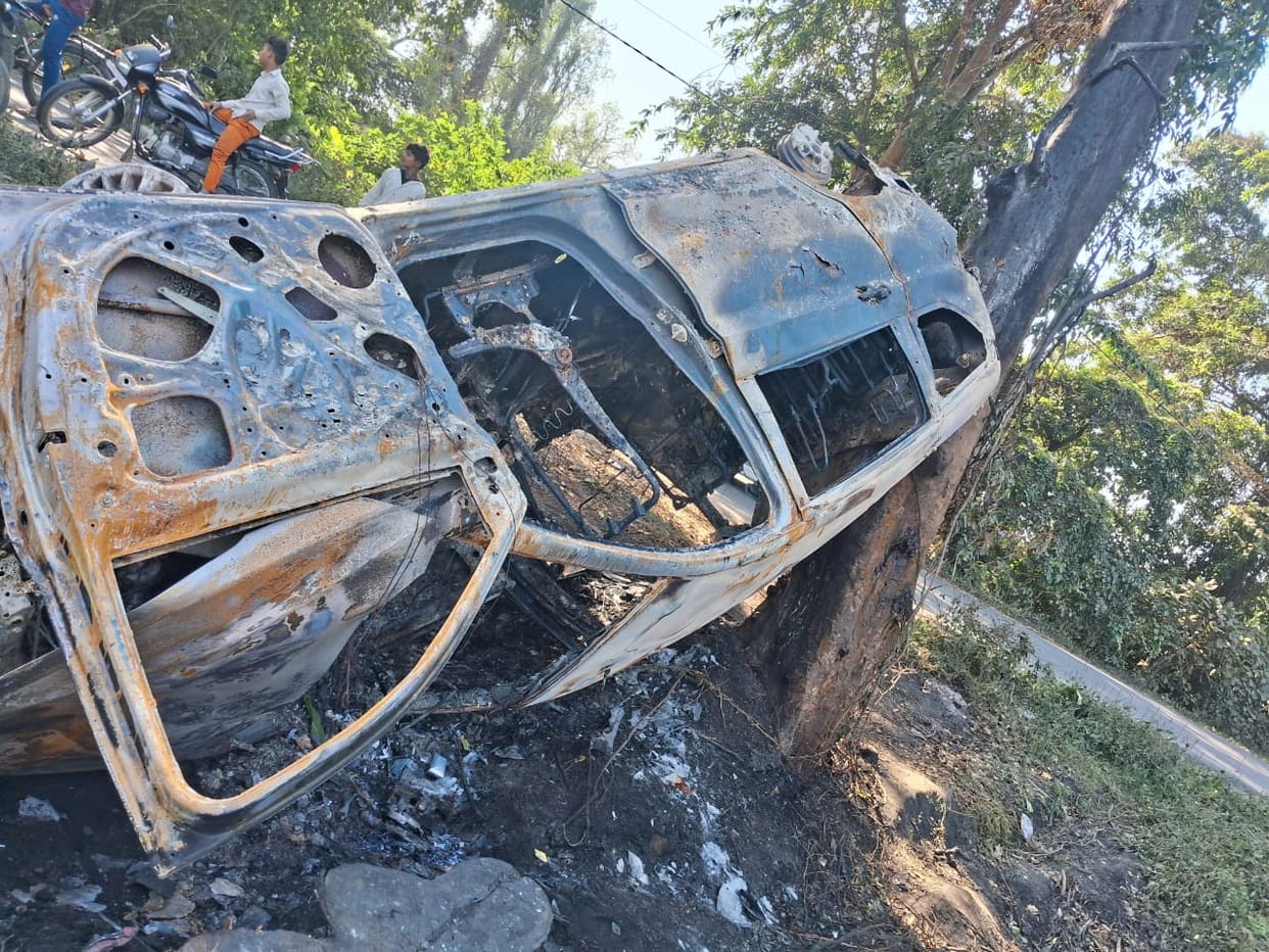 Car burnt after overturning in a pit